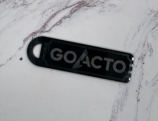 Black 'GOACTO' keychain on a white marble surface