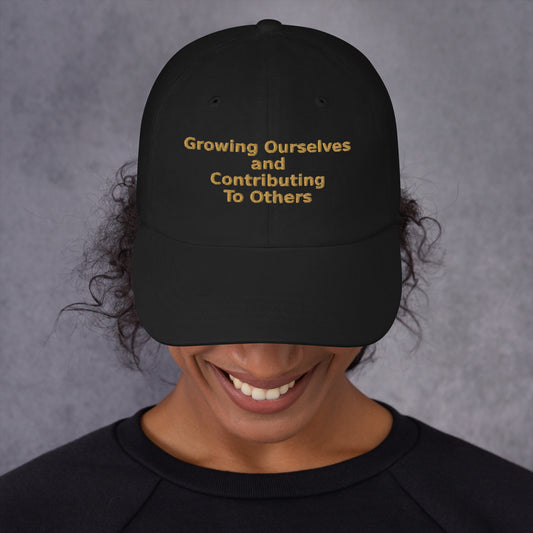 Black classic dad hat, front view, with "Growing Ourselves and Contributing To Others" embroidered in four lines of amber thread