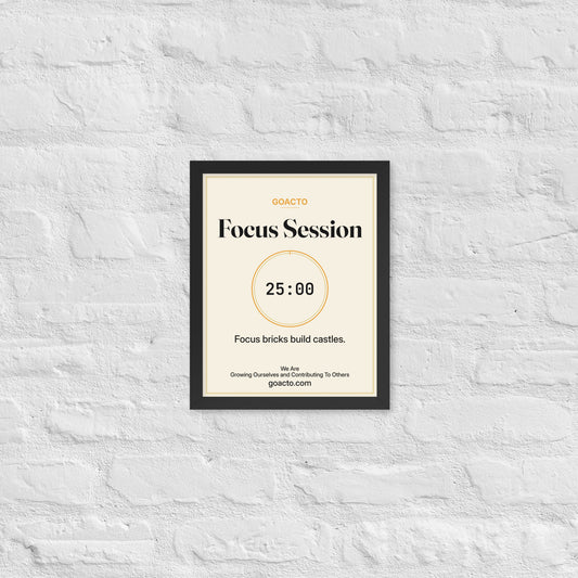 Focus Session Framed Print, Cream design, 11x14 in a black frame on a white brick wall: thin amber ring around a dark 25:00 timer, with dark type on a cream background, the line 'Focus bricks build castles.' and 'We Are / Growing Ourselves and Contributing To Others' above goacto.com