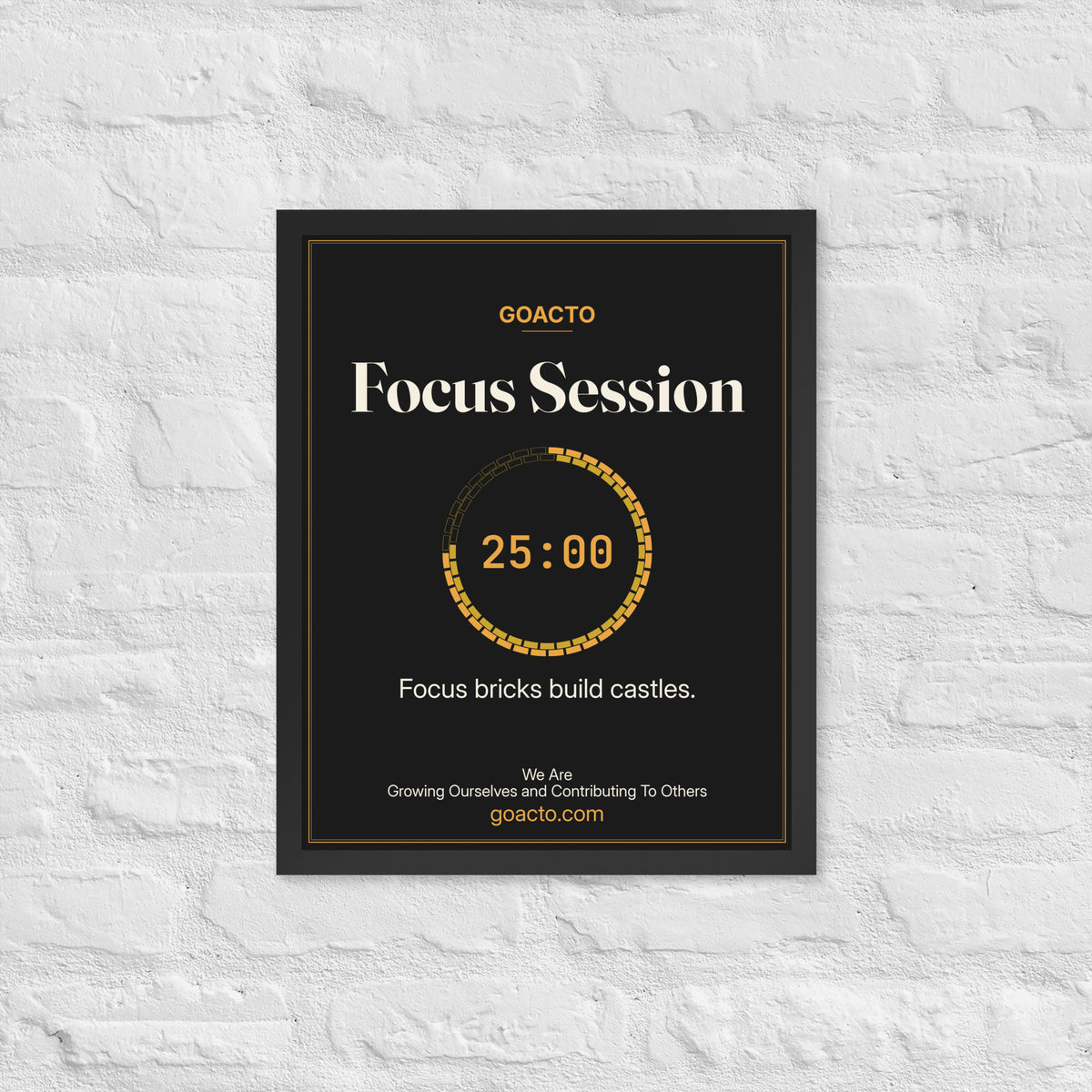 Focus Session Framed Print, Brick Ring design, 16x20 in a black frame on a white brick wall: ring of amber bricks around a 25:00 timer, on charcoal, the line 'Focus bricks build castles.' and 'We Are / Growing Ourselves and Contributing To Others' above goacto.com