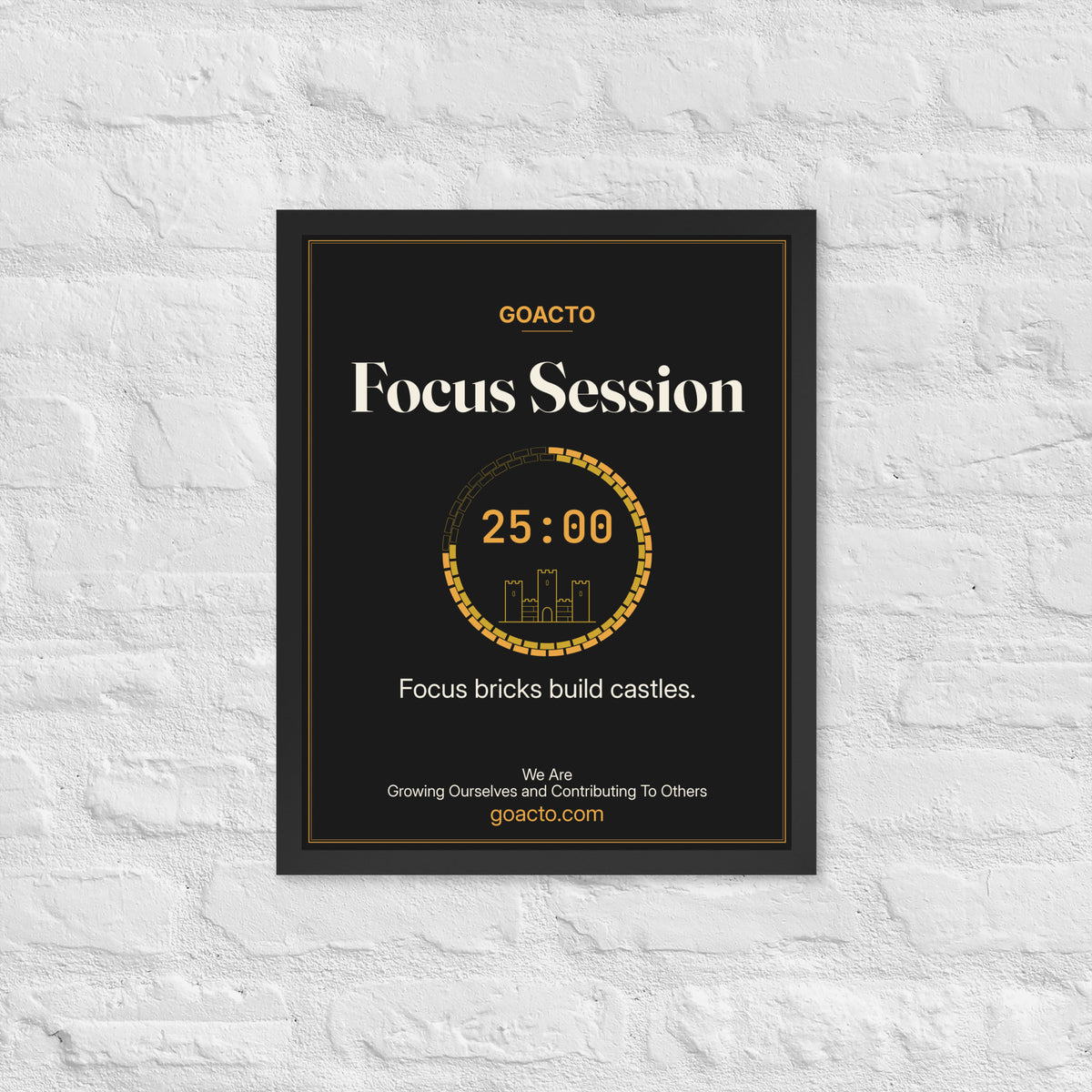 Focus Session Framed Print, Castle Ring design, 16x20 in a black frame on a white brick wall: ring of amber bricks around a 25:00 timer with a small line-drawn castle inside, on charcoal, the line 'Focus bricks build castles.' and 'We Are / Growing Ourselves and Contributing To Others' above goacto.com