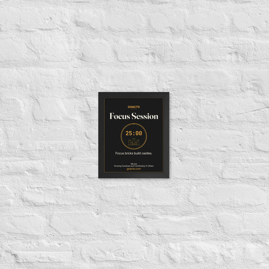 Focus Session Framed Print, Brick Rise design, 8x10 in a black frame on a white brick wall: thin amber ring around a 25:00 timer with a small line-drawn castle inside, on charcoal, the line 'Focus bricks build castles.' and 'We Are / Growing Ourselves and Contributing To Others' above goacto.com