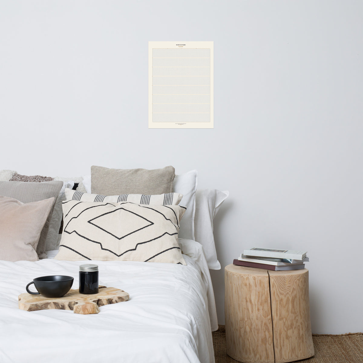 Memento Mori Tracker by GOACTO (18×24) poster mockup: cream week grid with a serif MEMENTO MORI header, hanging above a bed with a breakfast tray and a wooden side stool