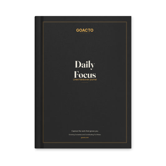 Daily Focus hardcover journal, front cover: matte night-black cover with the "Daily Focus" title in cream serif lettering inside an amber frame